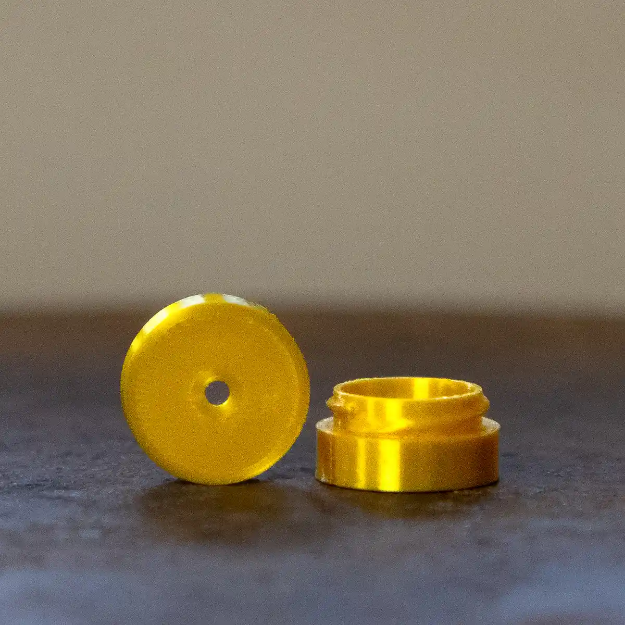 Gul dofthållare till nose work med ett litet runt hål.