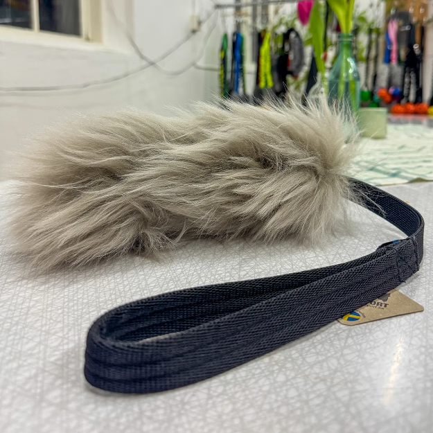 Fårex är en fluffig fårskinsleksak med kort, fast expander och bekvämt handtag.